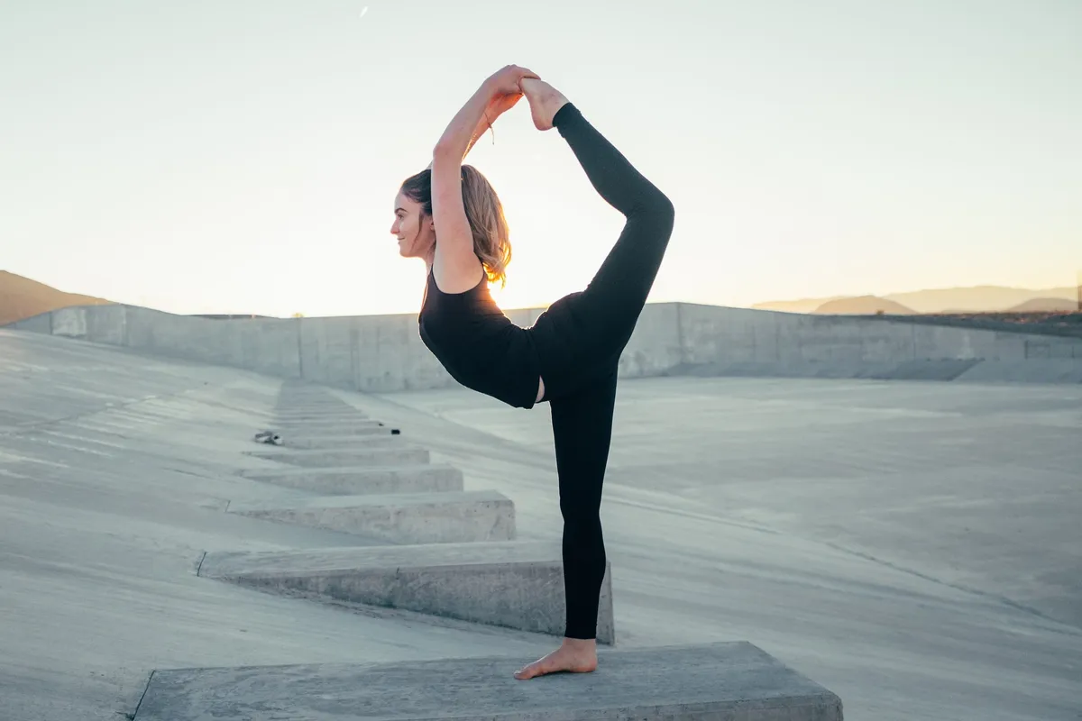A woman stretching outdoors at sunset